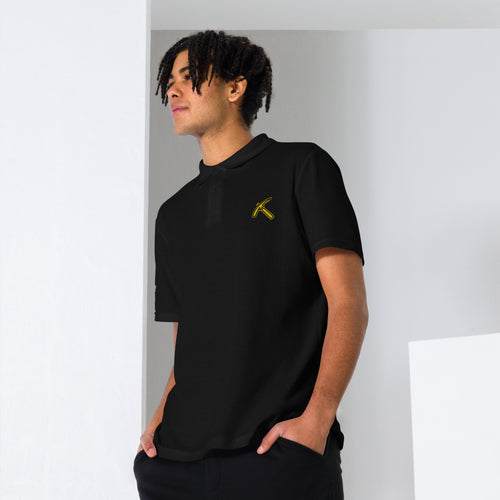 Pickaxe Pique Polo in black, front view, featuring gold pickaxe chest logo